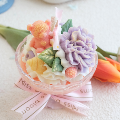 Miss Blooms Blossom Big Sundae Candle in wide glass bowl with purple carnation, bear figurine and pastel wax flowers, pink Miss Blooms ribbon