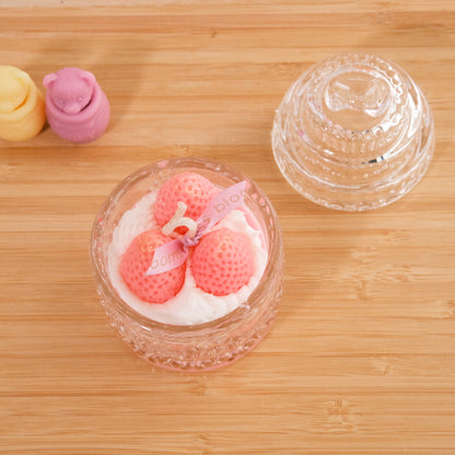 Miss Blooms Sweet Treats Sparkle Jar Candle in round glass jar with lid removed, topped with three pink strawberry wax sculptures on bamboo surface