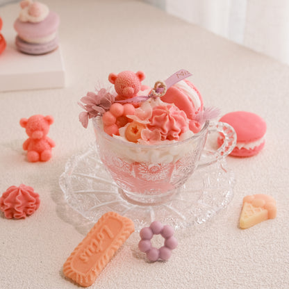 Miss Blooms Sweet Treats Candle with Teddy Bear in Vintage Crystal Teacup — pink bear and rose floral wax decorations, macarons scattered on surface