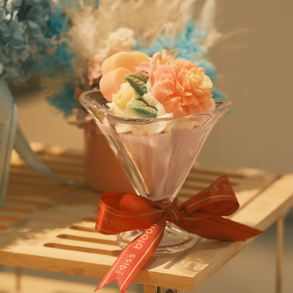 Miss Blooms Flower Cup Candle from the side showing elegant martini glass silhouette with coral floral wax topping