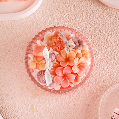 Miss Blooms Flower Bowl Candle top-down view of coral hibiscus and pink flower wax arrangement in pink scalloped bowl