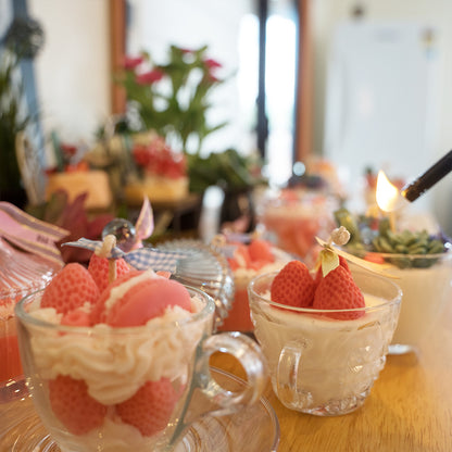Miss Blooms Strawberry Tea Cup Candle with strawberry wax toppings in glass teacup on wooden table